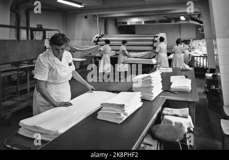 Oslo 19600106. Im Jahr 1960 hatte NSB 3212 Betten in ihren Schlafwagen, und sie wurden immer beliebter. Jeden Tag zog eine Armee von Reinigungskräften in das NSB-Gebiet in Lodalen, um die Bettwäsche zu waschen, zu reinigen und zu wechseln. Die Wäsche wird hier in die Wäsche von NSB in Lodalen gebracht, die jährlich etwa 3.000.000 Bettschichten oder fast 1,5 Millionen Kilo Kleidung nur aus den Schlafwagen wäscht. Um Weihnachten gibt es oft 3000 Laken pro Tag! Foto: Ivar Aaserud / Aktuell / NTB Stockfoto