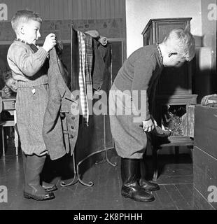 Aurskog 11 February 1956 'Diese Kinder haben 3 Meilen Schulstraße' die jungen Kinder Kjell aus Nybak, Hallvard aus Sinkerud und Marit aus Stenshaugen müssen 6 km allein durch den nächtlichen Schwarzwald laufen, bevor sie den Schulbus in Bekkesaga erreichen. Sie müssen um 5 Uhr aufstehen, um den Bus zu erreichen, der zur Haneborg-Schule in Aurskog fährt. Nach zweieinhalb Stunden Schulzeit ist es gut, in die Hitze zu kommen und Socken und Fäustlinge zum Trocknen aufhängen zu lassen. Foto; Sverre A. Børretzen / Aktuell / NTB Stockfoto