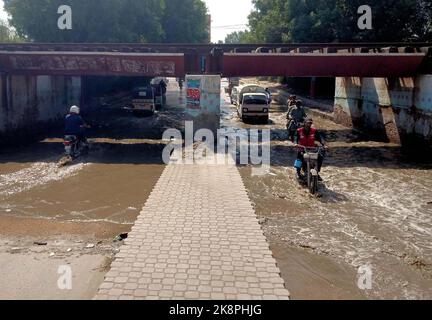 Hyderabad, Pakistan, 24. Oktober 2022. Überflutete Straße durch überlaufendes Kanalisationswasser, die Anwohner und Pendler mit Nachlässigkeit betroffener Behörden in der Latifabad-Eisenbahnübergangsbrücke in Hyderabad am Montag, 24. Oktober 2022, in Schwierigkeiten gebracht hat. Stockfoto