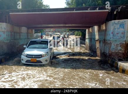 Hyderabad, Pakistan, 24. Oktober 2022. Überflutete Straße durch überlaufendes Kanalisationswasser, die Anwohner und Pendler mit Nachlässigkeit betroffener Behörden in der Latifabad-Eisenbahnübergangsbrücke in Hyderabad am Montag, 24. Oktober 2022, in Schwierigkeiten gebracht hat. Stockfoto