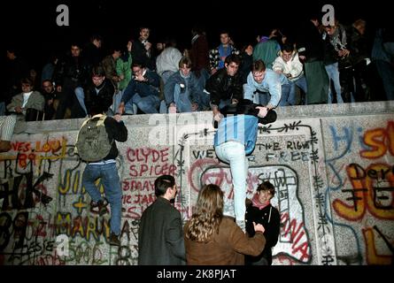 Berlin, Deutschland 19891110 Fall der Berliner Mauer: Am Freitagabend krochen Tausende Menschen die Mauer am Brandenburger Tor in Vest-Berlin hinauf. .. Foto von Jugendlichen, die die Wand hochklettern. Foto: Jørn H. Moen / NTB gescannt in 60 MB Stockfoto