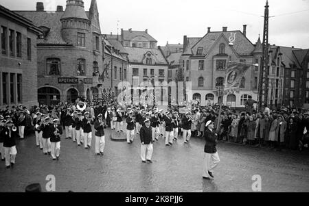 Ålesund 19480413: 100.-jähriges Jubiläum der Stadt Ålesund. Das Jubiläum wurde in vielerlei Hinsicht gefeiert, unter anderem mit einem großen Menschen- und Kinderzug durch die Stadt. Die strömenden Regenfälle dämpften die Partyatmosphäre nicht. Hier marschiert Ålesund Musikkorps aus Apotekergata über den Apothekenplatz. Die alte Jugendstilapotheke im Hintergrund. Foto: Aktuell / NTB Foto: Stockfoto