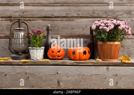 halloween Kürbisse zu Hause Dekorationen mit Blumen. Verschiedene Retro-Flaschen. Herbstschmuck. Stockfoto