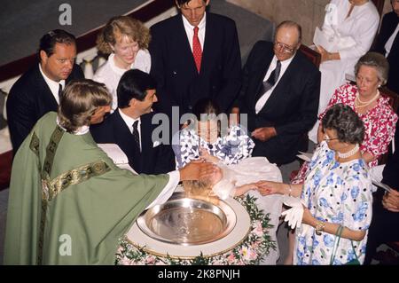 Oslo 19890620: Ingeborgs Tochter von Prinzessin Ragnhild und Erling Lorentzen tauft ihre Tochter Victoria Ragna Ribeiro in der Schlosskapelle. Hier am Taufbecken Eltern Paulo Ribeiro und Ingeborg mit dem Kind. Rechts die Prinzessin Arid, die Prinzessin Ragnhild und der Olderfar-König Olav. Prinzessin Taufpöbelchen tröstet das Kind, das unter der Taufe weint. Foto: Knut Falch Scanfoto / NTB Stockfoto