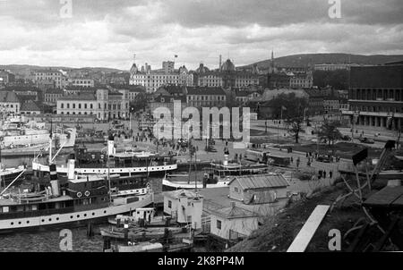 Oslo 19450514 Friedenstage 1945. Oslo Harbour, Übersichtsbild. Viele Boote auf Haven. Norwegische Flaggen und britische Flaggen am Kai. Das Bild zeigt auch die Vestbanen (TV) Victoria Terrace (im Hintergrund, in der Mitte) und einen Teil des im Bau befindlichen Rathauses (TH) Foto: LYNAU / NTB / NTB (Bild 2 in einer Serie von alten und neuen Aufnahmen des gleichen Motivs) Stockfoto