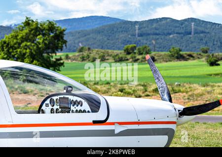 Ultraleichtes einmotorisches Flugzeug, das auf dem Flugplatz mit blauem Himmel und Feldhintergrund abheben soll Stockfoto