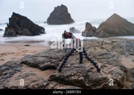 Digitale spiegellose Fotokamera auf flexiblem Stativ, um Fotos von der Meereslandschaft zu machen. Fotokamera auf beweglichem Stativ Stockfoto