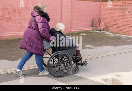 Blackpool, Großbritannien 15, Oktober 2022 Frauen schieben eine ältere Dame in einen Rollstuhl Stockfoto