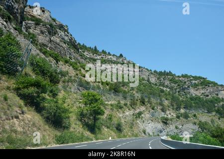 Berg mit Sicherheitszaun, um die Straße und Autos vor fallenden Felsen zu schützen. Hochleistungs-Drahtnetz verwendet, um fallende Felsen von den Klippen in fangen Stockfoto