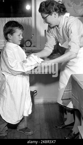 Oslo Weihnachten 1958. Kinder backen Lebkuchen. Eines Tages während der Weihnachtszeit interessierten sich die Jungen der Mutter plötzlich für häusliche Aktivitäten und begannen, die Küche zu benutzen, die den Mädchen vorbehalten war. Drei Brüder werden zu Weihnachten Lebkuchenmänner machen. Ein Bäcker ist kein Bäcker ohne Schürze und Backhut. Das Hemd des Vaters und eine weiße Papiertüte waren der Service. Foto: Aage Storløkken NTB / NTB Stockfoto