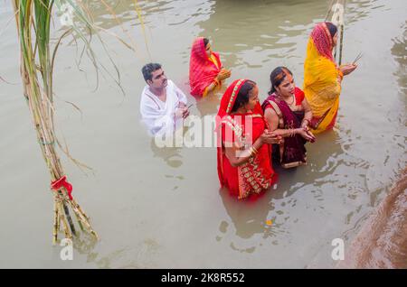 Nicht identifizierte indische Männer und Frauen beten und widmen sich dem Chhath Puja-Festival am Ganges-Fluss in Varanasi, Indien. Stockfoto