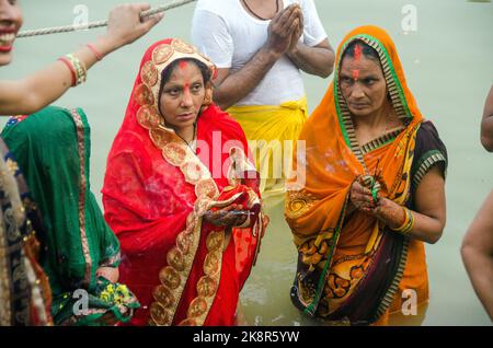 Nicht identifizierte indische Männer und Frauen beten und widmen sich dem Chhath Puja-Festival am Ganges-Fluss in Varanasi, Indien. Stockfoto