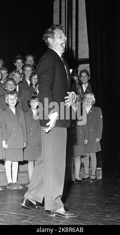 Oslo 1955: Entertainer und Filmschauspieler Danny Kaye reist als Botschafter des UN-Kinderhilfswerks UNICEF um die Welt. Er möchte gerne als ernsthafter und hart arbeitender Botschafter für die Benachteiligten auftreten, aber die Kieferfreude wurde nie verspielt, vor allem nicht, wenn er mit Kindern auftrat. Hier Kaye unter einer UN Matine im Saga-Kino, wo er sich mit den Mitgliedern eines Liederchores amüsiert, was sein Jonglieren zu schätzen scheint. Foto: Gerald Pagano / Current / NTB Stockfoto