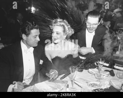 Oslo. Das Regenbogenrestaurant. Karnevalnacht im Zeichen von Schüssen. Die Schriftstellervereinigung veranstaltet den Shooting Year Karneval in Oslo für Einkommen für alte, unproduktive Schriftsteller und Witwen von Schreibern. Hier sind die beiden Ehrengäste des Karnevals, alle von Oslos glücklicher Witwe Wenche Foss und Poul Reichardt. Hinter dem Frühlingshut für Wenche Foss ist der Filmproduzent Alf Scott-Hansen zu sehen. Foto: NTB Stockfoto