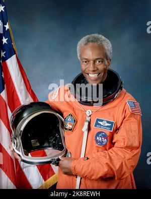 Offizielles Porträt des Astronauten Guion S. Bluford. Bluford, Mitglied der Astronaut-Klasse 8 und der United States Air Force (USAF), posiert in seinem Starts- und Entry Suit (LES) mit einem Starts- und Entry-Helm (LEH) und der US-Flagge als Hintergrund. Stockfoto