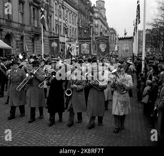 Oslo 19540501. Mai 1 Zug entlang Karl Johans Tor. Tabs und Banner, Zuschauer folgen dem Zug und Männer spielen, Posaune, Saxophon und Althorn. Foto: NTB / NTB Stockfoto