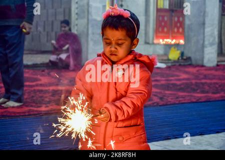 Srinagar, Indien. 24. Oktober 2022. Am Vorabend des Diwali, dem hinduistischen Lichterfest, in Srinagar, zündet ein junger Anhänger Feuersünder am Tempel an. Deepavali oder Dipavali ist ein vier-fünf-Tage-Fest der Lichter, das von Hindus in jedem Herbst auf der ganzen Welt gefeiert wird. Kredit: SOPA Images Limited/Alamy Live Nachrichten Stockfoto