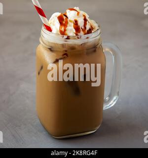 Hausgemachter Karamell-Eislatte mit Schlagsahne in einem Glasglas, Seitenansicht. Nahaufnahme. Stockfoto