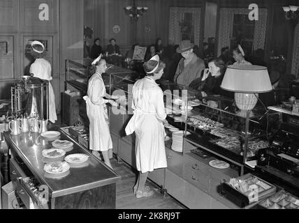 Oslo 19530201 Interieur aus Møllhausen Konditori im Karl Johans Tor. Kunden an der Theke weibliche Disponenten mit weißen Schürzen und Kappen hinter der Theke. Foto: NTB / NTB Stockfoto