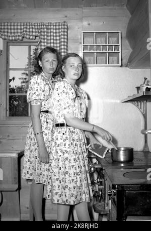 Asker 19460524. Die Kronprinzenfamilie fotografierte in Skaugum. Hier sehen wir (TV) Prinzessin Astin Prinzessin Ragnhild beim Kochen in der Küche. Die Prinzessinnen mit gleichen Kleidern. Foto: NTB Archive / NTB Stockfoto