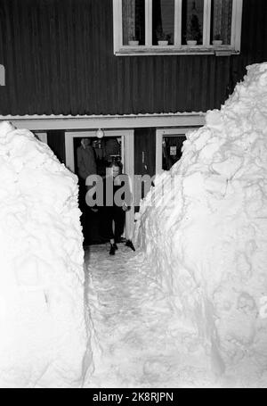 Südnorwegen, Februar 1951: Starker Schneefall über dem südlichen Teil des Landes verursachte wochenlang Chaos. Hier ist der Laden von Gunnar Seland, der bis auf den Eingang komplett mit Schnee bedeckt ist. Das einzige, was in der Vitrine scheint, ist eine Werbung für Zahnspangen. Der Kunde kommt aus dem Geschäft. Foto: Arne Kjus / Aktuell / NTB Stockfoto