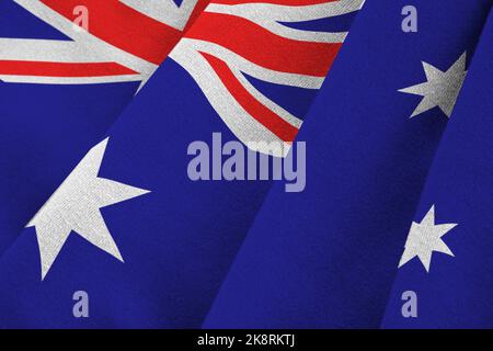 Australien Flagge mit großen Falten winken aus nächster Nähe unter dem Studiolicht im Innenbereich. Die offiziellen Symbole und Farben in Stoff Banner Stockfoto