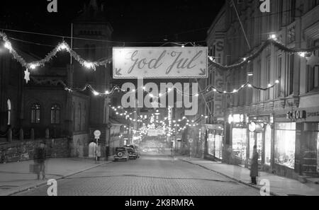 Oslo 19511223. Weihnachtliche Atmosphäre am Fuße des Karl Johans-Tores. Weihnachtsstraße mit großem Schild mit dem Text Frohe Weihnachten. Altmodisch. Foto: NTB / NTB Stockfoto