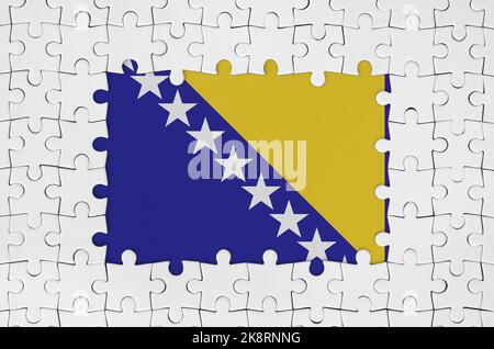 Bosnien und Herzegowina Flagge im Rahmen von weißen Puzzleteilen mit fehlenden zentralen Teilen Stockfoto