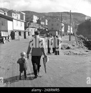 Honningsvåg 19521115. Recovery-Arbeit von Fiskevær Honningsvåg on Magerøya. 5 Jahre nach dem Krieg von 1947 bis 1952 spiegelt sich hier die Wohnreise voll und ganz in den Bildern wider. Die Deutschen legten Honningsvåg in Kies. Nach dem Krieg befand sich der Ort in einem chaotischen Ruinhaug, wo die Kirche als einziges Gebäude zurückgelassen wurde. Es wird gegraben und gesprengt. Auf dem Bild sehen wir Ehemann und Kinder, die Fische tragen. Foto: Sverre A. Børretzen / Aktuell / NTB Stockfoto