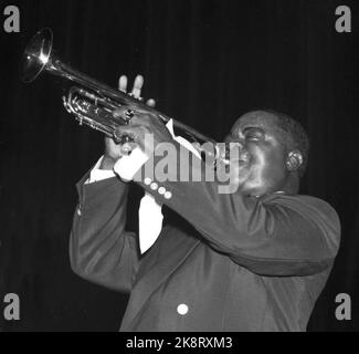 Oslo 1952; der Trompetengänger und Sänger Louis Armstrong (1901-1971) gab ein großartiges Konzert im Kolosseum-Kino in Oslo und trug damit maßgeblich zum Jazzfieber in der Hauptstadt im Jahr 50s bei. Die markante Stimme, das herausragende Trompetenspiel und das Besitzrecht des charmanten Künstlers an Armstrong zogen das Publikum an, das aus Enthusiasten bestand, die ebenfalls die Nacht in der Schlange verbracht hatten, um einen der über 2000 Sitzplätze im Kinosaal zu sichern. Hier spielt Armstrong ein Solo. Cozy Coles Bassdrum erscheint im Hintergrund auf der Bühne. Foto; Sverre A. Børretzen / Aktuell / NTB Stockfoto