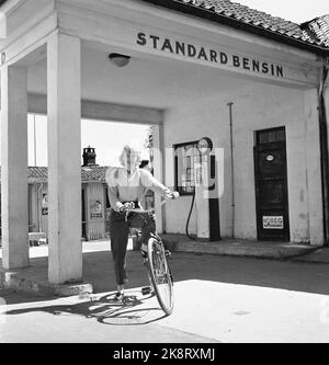 Kragerø 195406 - Sommerbilder aus Kragerø. Junge Frau mit Fahrrad außerhalb der Tankstelle Standard Benzin. Foto: Current / NTB Stockfoto