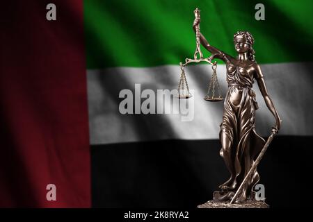 Flagge der Vereinigten Arabischen Emirate mit Statue der Justizdame und Justizwaagen in dunklem Raum. Konzept von Urteil und Strafe, Hintergrund für Jury-Thema Stockfoto