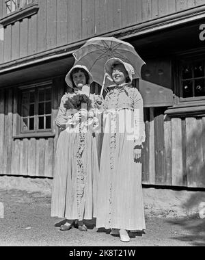 Bygdøy 19570825 Parade von alten Fahrrädern im Volksmuseum. Unter den Zuschauern zwei Frauen, modisch gekleidet mit langen Kleidern und Küssen, und Sonnenschirm. Foto: Jan Nordby / NTB / NTB Stockfoto