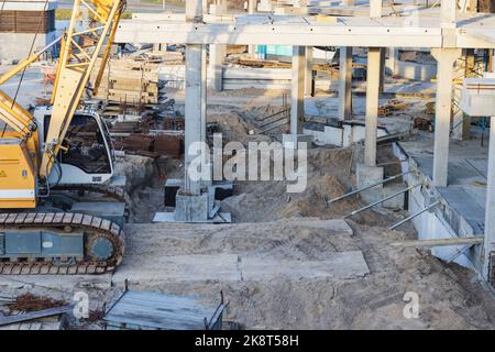 Kran und Gebäude im Bau gegen blauen Himmel am Seeufer Stockfoto