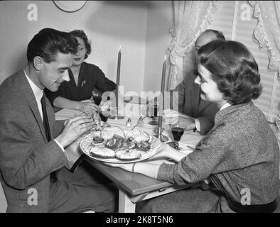 Oslo 19550209 'Mr. And Mrs. Lykke' Illustration Fotos zum Artikel über die glückliche Ehe, fotografiert von NTB im Februar 1955. Hier hält das Ehepaar eine Gesellschaft, und eine lächelnde Frau Lykke dient. Kerzen auf dem Tisch. Foto: NTB / NTB das Modell heißt Ellinor Øygard, oft 'Bibba' genannt. Stockfoto