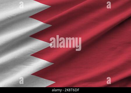 Bahrain-Flagge mit großen Falten, die in Innenräumen unter dem Studiolicht winken. Die offiziellen Symbole und Farben in Stoff Banner Stockfoto