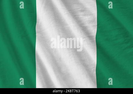 Nigeria Flagge mit großen Falten winken aus nächster Nähe unter dem Studiolicht im Innenbereich. Die offiziellen Symbole und Farben in Stoff Banner Stockfoto