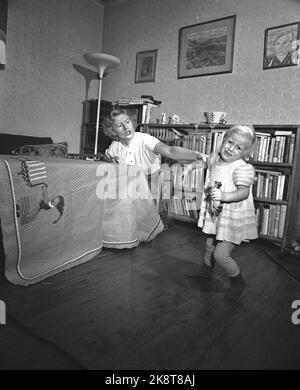 Oslo 19540109 Sie sind in Gefahr, wo Sie hingehen das Zuhause ist ein gefährlicheres Arbeitsumfeld, als viele Hausfrauen wissen. Hausunfälle, Illustration Foto. Mutter hält den Arm eines kleinen Mädchens. Kämpfen. Foto: Sverre A. Børretzen / Aktuell / NTB Stockfoto