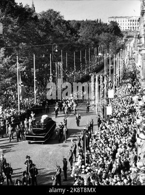 Oslo 19571001. Das Begräbnis von König Haakon. König Olav und Kronprinz Harald folgen der Bahre zu Fuß vom Schloss zum Dom. Hier ist die Bahre am Karl Johans Tor. Menschenmassen entlang der Route. Das Schloss im Hintergrund. Foto ntb Stockfoto