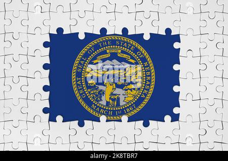 US-Staatsflagge von Nebraska im Rahmen von weißen Puzzleteilen mit fehlenden zentralen Teilen Stockfoto