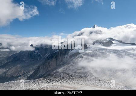 Chamonix, Frankreich - 31. August 2022: Der Gipfel des Dent du Geant im Mont Blanc-Massiv, der durch die Wolkendecke mit der Gletscherspalte auftaucht Stockfoto