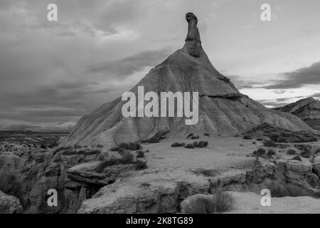 Eine Graustufenaufnahme eines Sandsteinturms, der durch Erosion auf den Bardenas Reales in Navarra, Spanien, entstanden ist Stockfoto