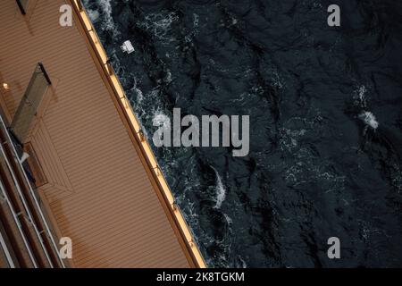 Ein Blick von oben auf die Wellen, die sich in der Nähe einer hölzernen Plattform waschen Stockfoto