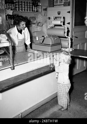 Oslo 19550915. In Norwegen war es in diesem Sommer aufgrund der Dürre und des anschließenden Milchstreiks Milchmangel, weil die Bauern mit den Subventionen der Regierung an die Streikenden unzufrieden waren. Ein kleines Mädchen kommt mit einer leeren Milchflasche in den Milchladen / Kolonialladen, aber die Expedition der Theke kann sich nur beschweren, keine Milch zu kaufen. Kasse. Foto: NTB / NTB Stockfoto