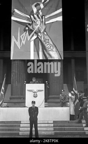 Oslo 19440515 Norwegen während des Zweiten Weltkriegs. Ministerpräsident Vidkun Quisling spricht auf dem Universitätsplatz in Oslo gegen das, was er die Verräter in London nennt, und den Kampf gegen den Bolschewismus. Quisling auf der Kanzel. Deutscher Adler und Sonnenkreuz auf der Kanzel. Im Hintergrund ein Propagandaplakat gegen den Bolschewismus. Eine Hand mit tätowierten russischen Symbolen, Sternen, Hammer und Sichel reißt das Kreuz aus der norwegischen Flagge. Foto: Kihle / NTB / NTB Stockfoto