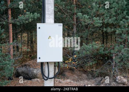 Elektrischer Metallkasten auf einem Mast. Elektrischer Schaltschrank auf einem Mast Stockfoto