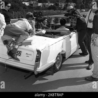 Oslo August 1965 Norwegische Dreharbeiten mit Vater und zwei Brüdern Bang-Hansen. Das Manuskript für den Film 'Schrift in SNE' stammt von Pater Odd Bang-Hansen, Regisseur ist der Sohn Pål Bang-Hansen mit Hut, hier liegt er über der Motorhaube des Autos. Der Filmfotograf befindet sich hinten im Auto. Hinter dem Steuer steht der Schauspieler Jack Fjeldstad. Foto: Aage Storløkken / Aktuell / NTB Stockfoto