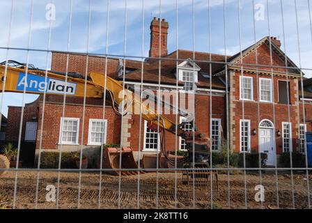 Zaun und Digger vor dem Roten Haus des Luxuseigentums, während des Abrisses aufgrund von Küstenerosion. Thorpeness 22.. Oktober 2022 Stockfoto