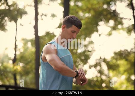 Mann Läufer in aktivewear Überprüfung der Zeit auf Tracker Stockfoto