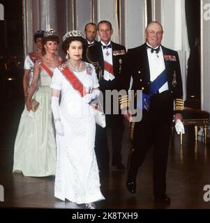 Oslo 19810505. Königin Elizabeth in Norwegen zu einem Staatsbesuch mit ihrem Mann. Galadiner im Schloss. Hier im Bild zuerst in der Serie von Königin Elizabeth und König Olav, hinter Kronprinzessin Sonja und Prinz Philip, Prinzessin Astred und Kronprinz Harald. Die Königin in weiß silbernem Kleid, weißer Tasche und langen weißen Handschuhen. Foto: NTB-Archiv Bjørn Sigurdsøn BM dias Stockfoto